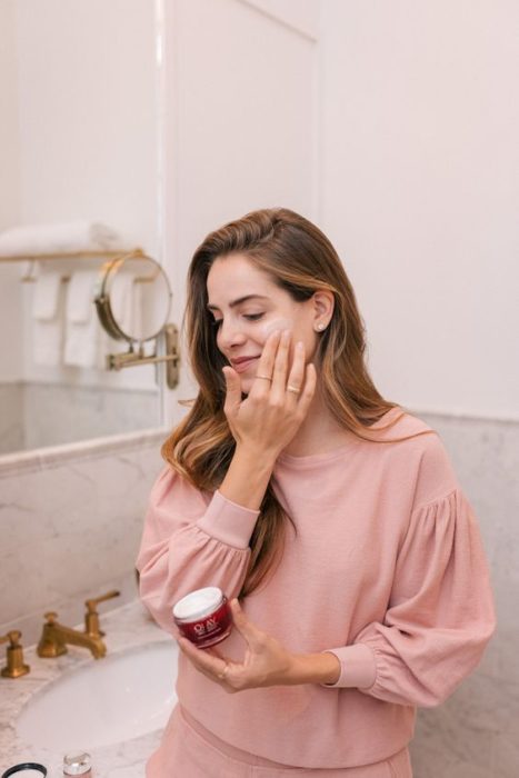 Mujer aplicándose crema en la cara