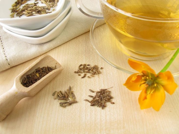 Te de hinojo en juego de tazas de cristal, adordano con flor de hinojo sobre mesa de madera