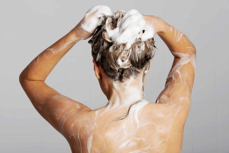 Chica rubia lavando su cabello