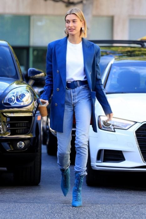 Hailey Bieber caminando por la calle mientras usa un blue look total 