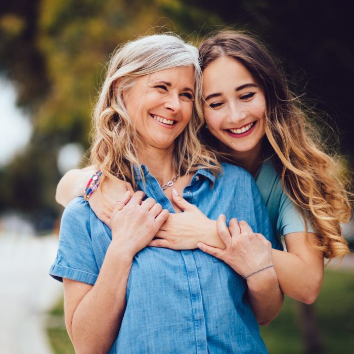 Hija abrazando a su madre, ambas sonríen