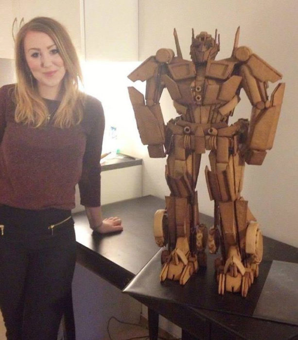 Chica parada junto a una estatua de transformers hecha con pan de gengibre 