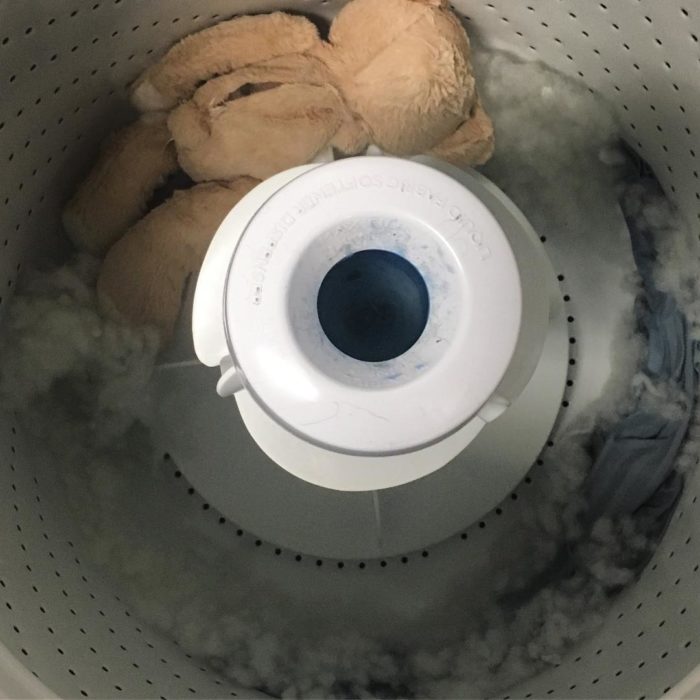 Lavadora con un osito dentro que está lavado 