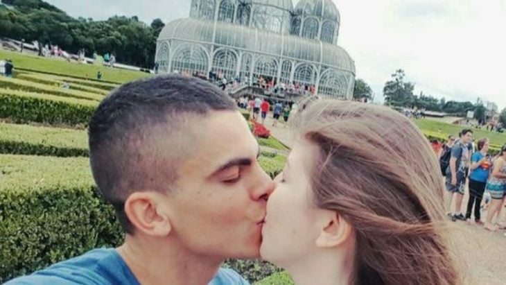 Pareja de novios durante sus vacaciones besándose 