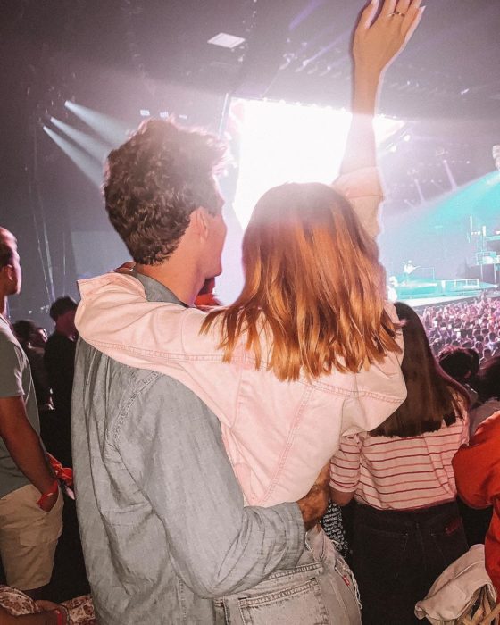 Pareja de novios abrazados mientra están en un concierto 