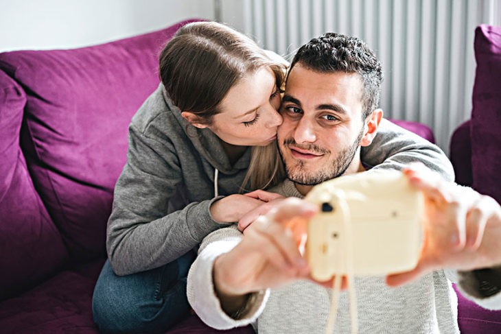 Coppie di cerimonia nuziale che catturano maschera con la macchina fotografica istantanea 