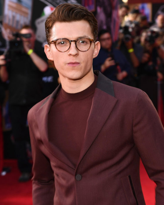 Tom Holland con traje de gala color vino y lentes; Spider-Man se unirá a comunidad LGBT+