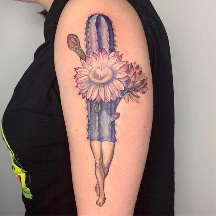 Tatuaje de un cactus azul, con flores nacientes y piernas