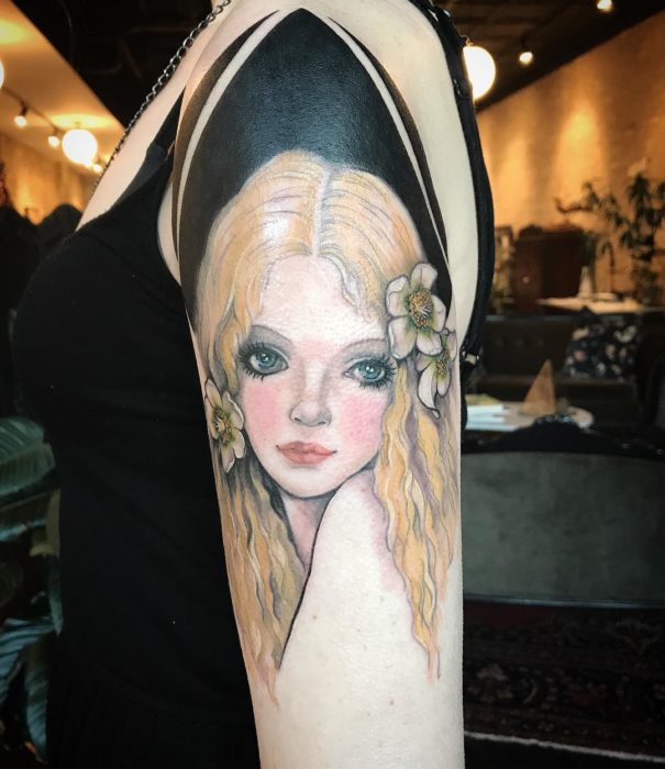 Tatuaje sobre brazo de rostro de mujer rubia