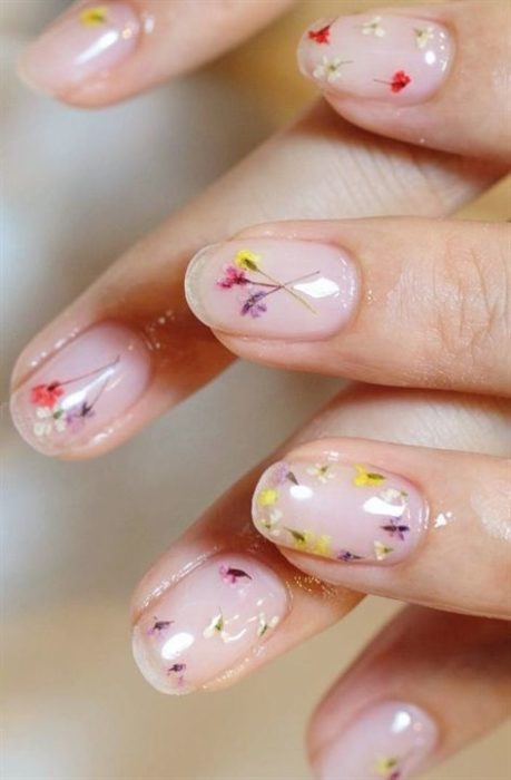 Manicura en efecto cristal con decorado de flores amarillas y lilas