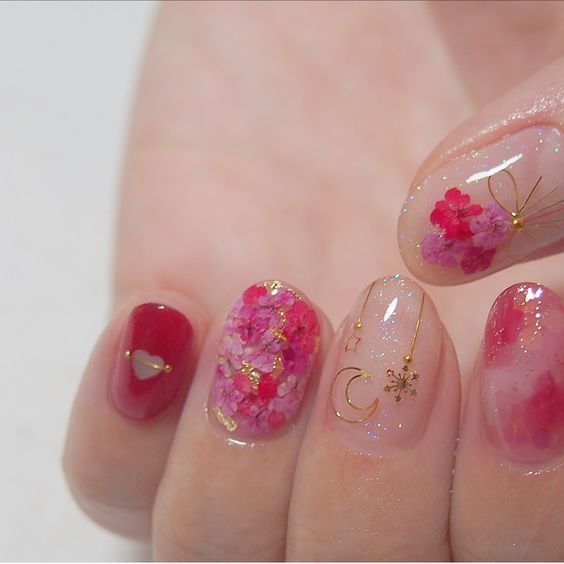 Manicura en tono rosa fucsia con flores doradas miniatura