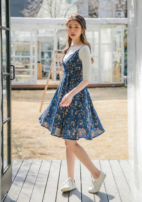 Looks con vestidos y blusas básicas; mujer coreana con peinado de media cola con trenzas, vestido azul de flores con blusa blanca de manga corta y tenis