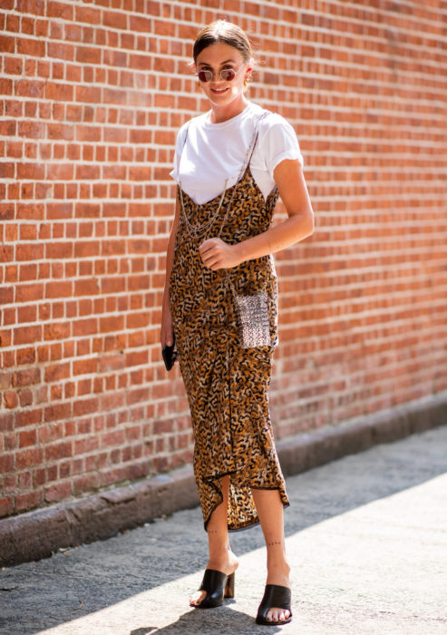 Looks con vestidos y blusas básicas; mujer con vestido oversized de animal print con blusa blanca y lentes pequeños