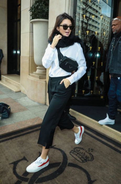 Kendall Jenner usando un outfit de color blanco y negro con una cangurera cruzada en el pecho