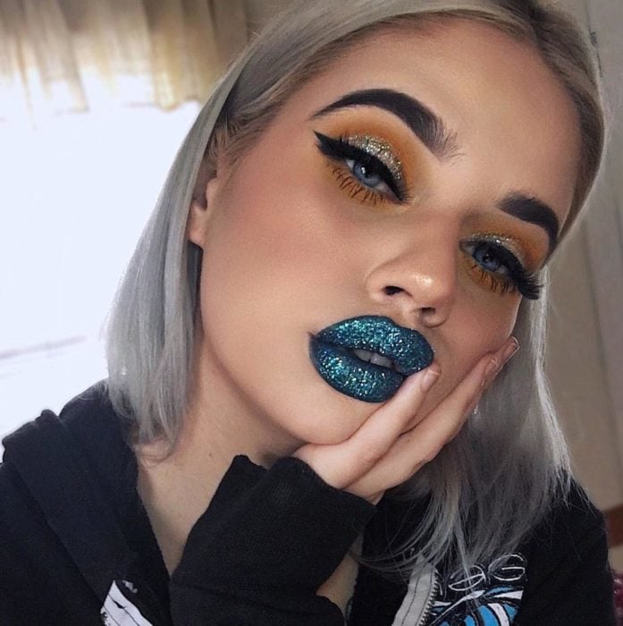 Chica usando maquillaje de glitter en color azul 