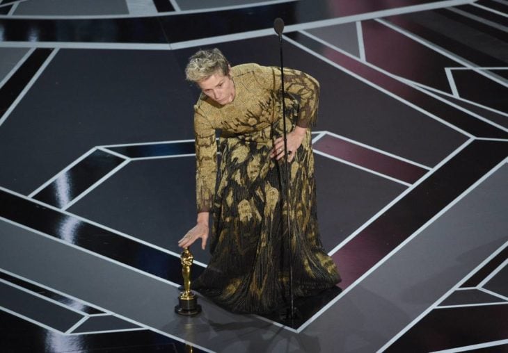Actriz poniendo su estatuilla de los Óscar en el suelo 