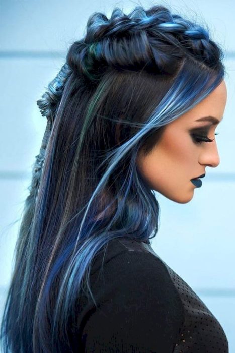 Chica con el cabello negro y azul sujetado en una trenza alta 