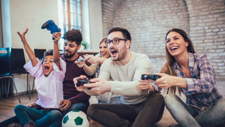 Familia reunida jugando videojuegos en la sala