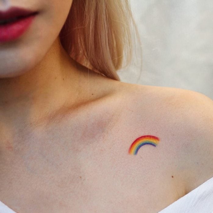 Tatuaje de arcoiris en la parte externa de la clavícula