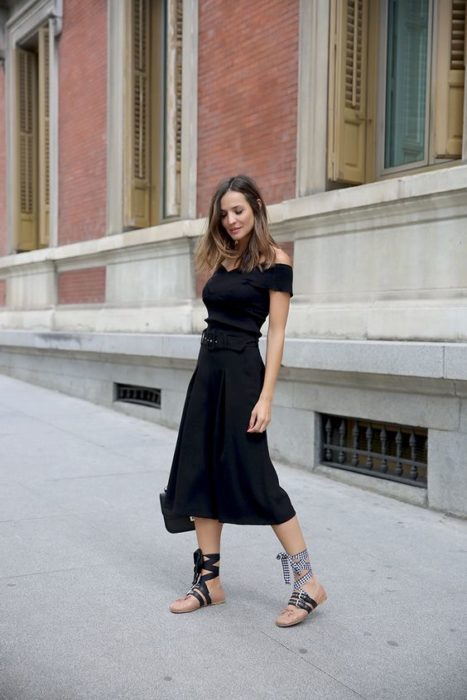 Mujer de cabello largo con vestido negro y ballerinas 