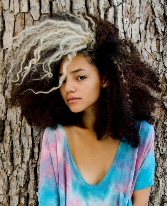 Cabello negro con blanco; chica afroamericana con cabello chino y un mechón rubio