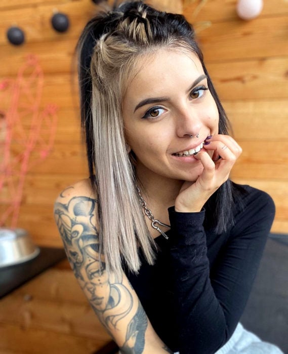 Cabello negro con blanco; chica con peinado de trenzas, tatuajes en el brazo y cabellera lacia