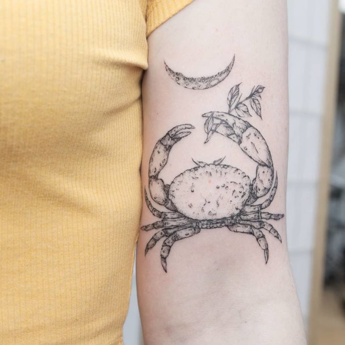 Tatuaje del signo de cancer en el antebrazo