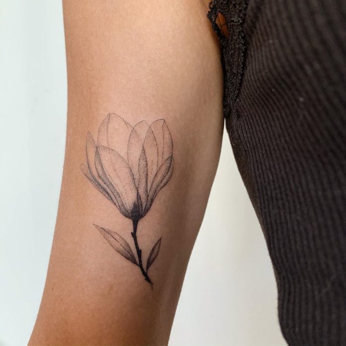 Tatuaje al estilo hand poke de capullo de una flor abriéndose en la parte interna del brazo