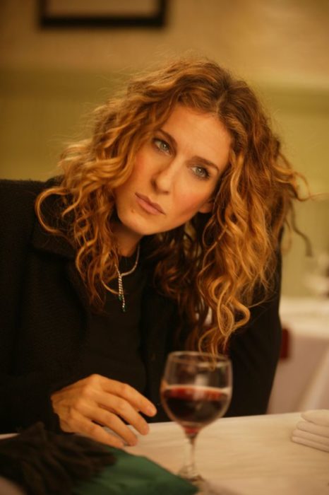 Carrie Bradshaw pesantiva tomando una copa de vino