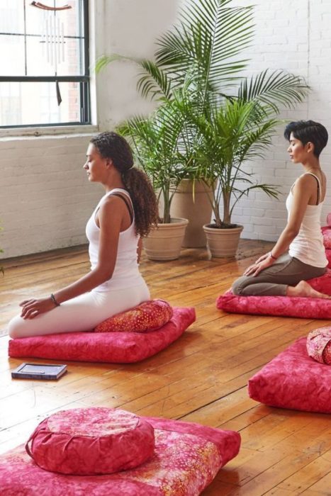 Chicas meditando en sala de meditación