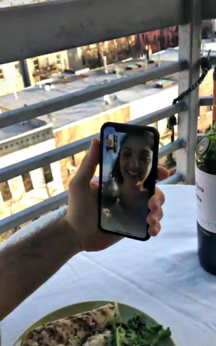 Pareja haciendo facetime durante una cena romántica 