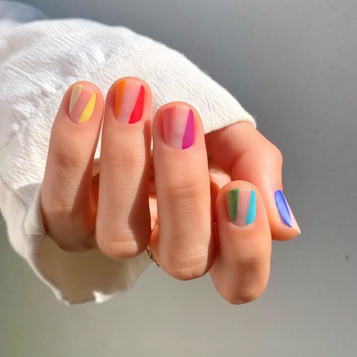 Manicura de colores con franja en medio de cada uña sin ningún tono