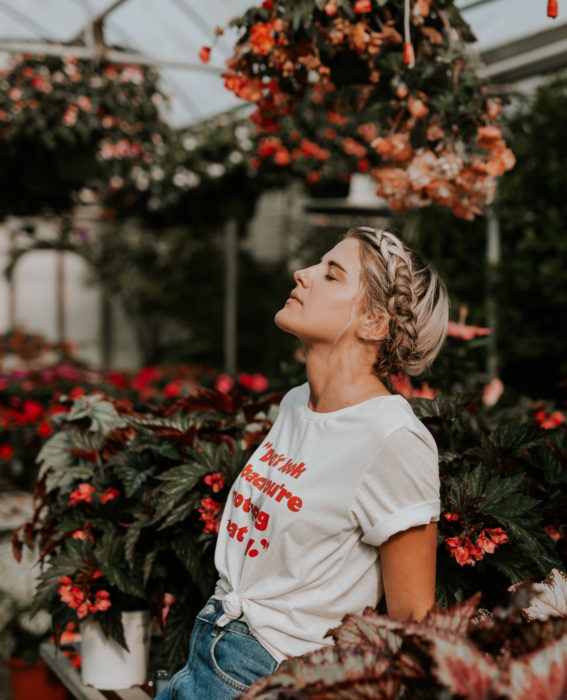 Astronauta de la NASA da consejos para pasar la cuarentena; mujer rubia con peinado de corona de trenza con los ojos cerrados en jardín