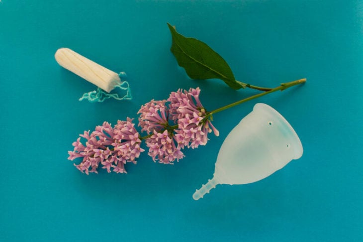 Tampon y copa menstrual y ramito de flores