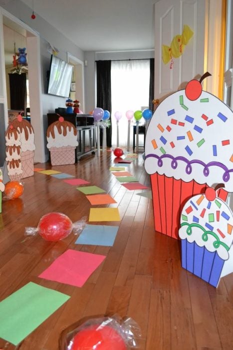 Camino con papeles de colores y decoración de cupcakes de cartón para fiesta infantil