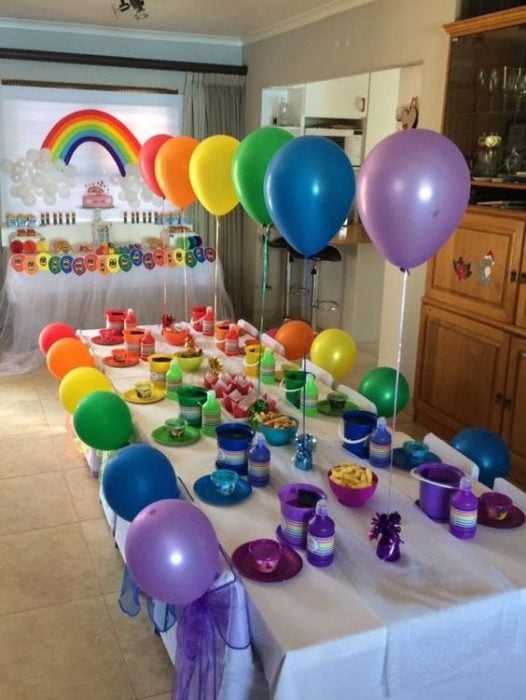 Decoración de mesa para fiesta infantil con globos y platos de colores