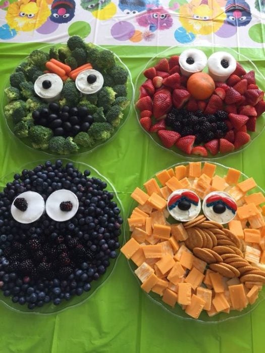 Platos con verduras y snacks con formas de caras para fiestas infantiles