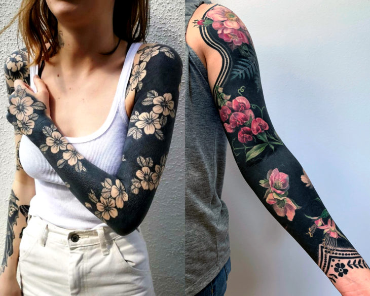 Estilos de tatuajes femeninos; blackout, tatuaje de flores en fondo negro en el brazo; full sleeve