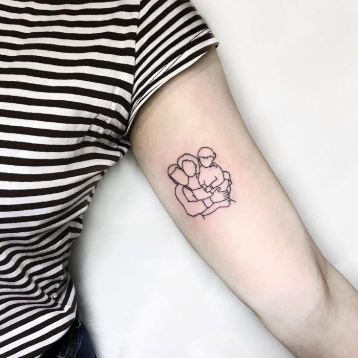 Tatuaje al estilo hand poke de la silueta de una familia abrazándose