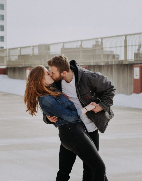 Pareja de novios besándose en el parque 