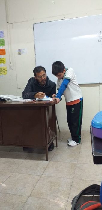 Maestro ayudando a niño hacer la tarea