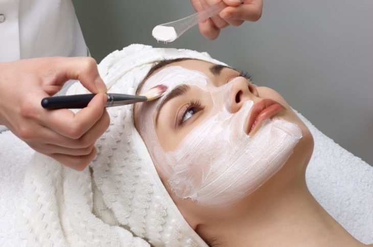 Mujer en un spa a la que le aplican una mascarilla