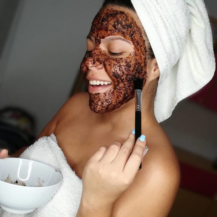 Chica aplicando una mascarilla facial de café