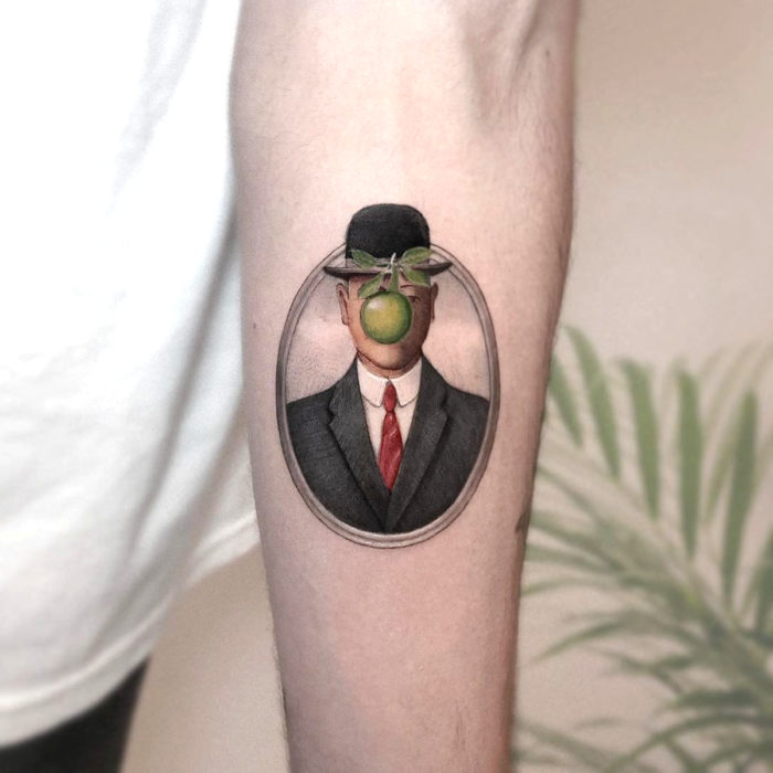 Minitatuajes realistas de Eden Kozokaro; El hijo del hombre por Rene Magritte