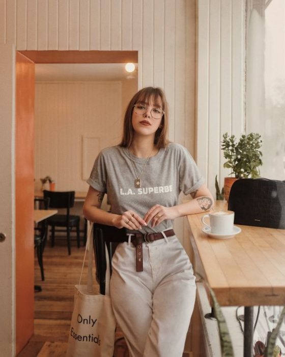 Chica con pantalón de tela ligera beige y playera gris