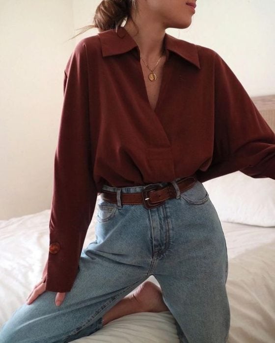 Mujer con jeans y blusa guinda