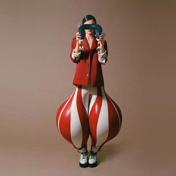 Chica usando unos pantalones en blanco y rojo hechos de látex y con la apariencia de un globo 