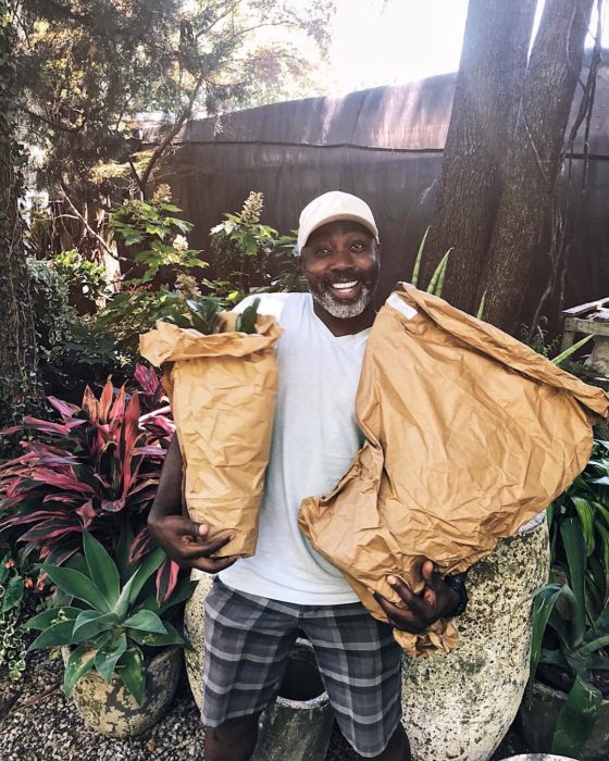 Peter con bolsas del mandado sonriéndo