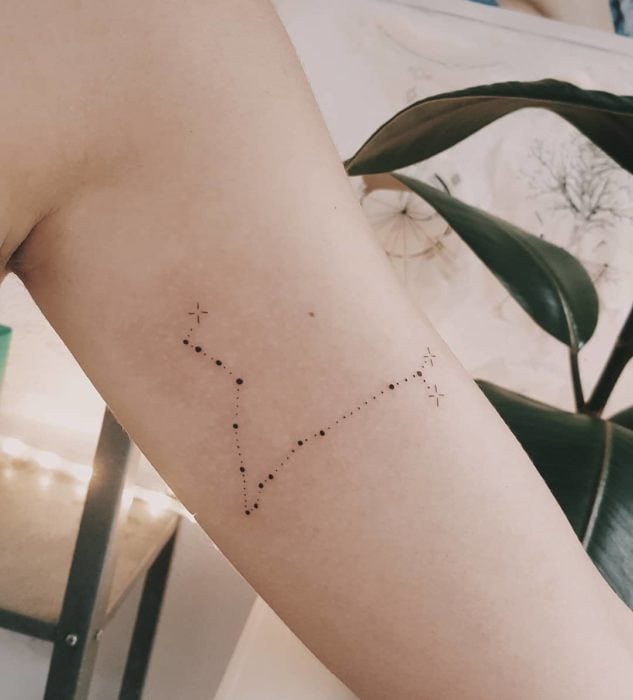 Tatuaje de la constelación de piscis en la parte interna del brazo a tinta negra