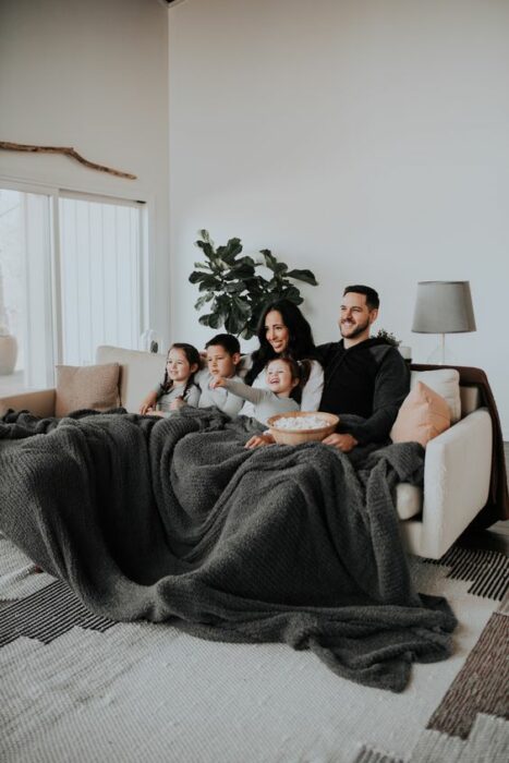 Familia recostada en la cama mientras ven películas 